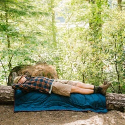 Rumpl The Original Puffy Blanket Turpledd (Deepwater) -Osprey Butikk Rumpl The Original Puffy Blanket Turpledd Deepwater modell sover ute